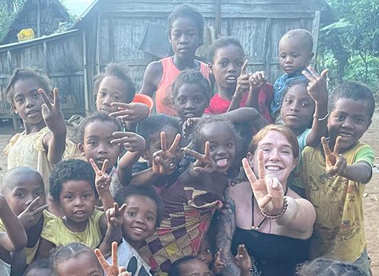 在线博彩校友和和平队志愿者Mackenzie Hafer带着孩子在马达加斯加